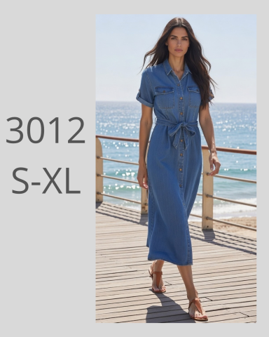 Mujer caminando por un muelle, luciendo un vestido azul y sandalias. Mar al fondo.