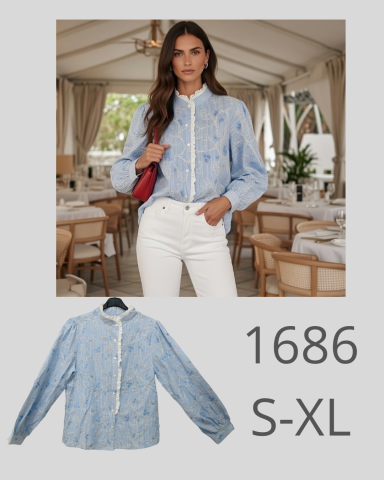 Mujer con blusa azul y pantalones blancos en un restaurante elegante.