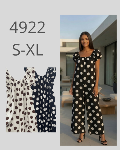 Mujer con vestido de lunares negros y blancos, de pie en un entorno moderno.
