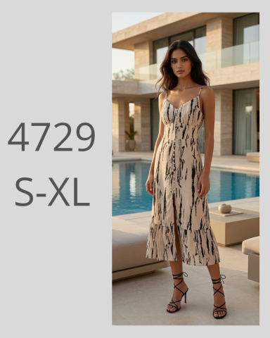 Mujer con vestido largo de estampado en un entorno moderno junto a una piscina.