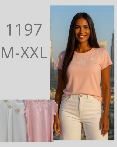 Mujer sonriente con camiseta rosa y pantalones blancos, fondo urbano. Tallas M-XXL.