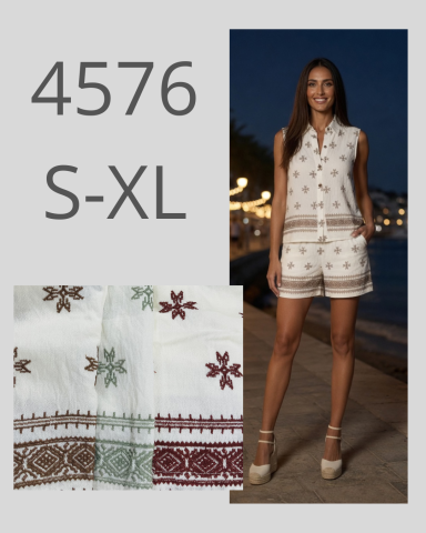 Mujer posando con un conjunto de ropa blanca con bordados en un entorno nocturno.