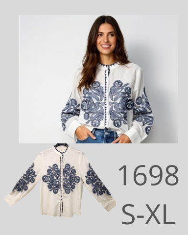 Mujer sonriente viste una chaqueta blanca con estampado azul. Tamaños S-XL disponibles.